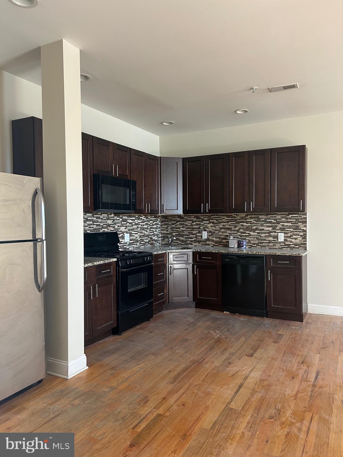 a kitchen with stainless steel appliances granite countertop a refrigerator and a stove top oven