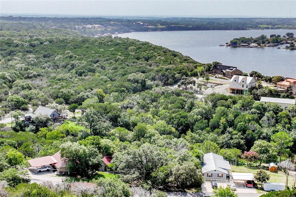 an aerial view of a house with a yard and lake view