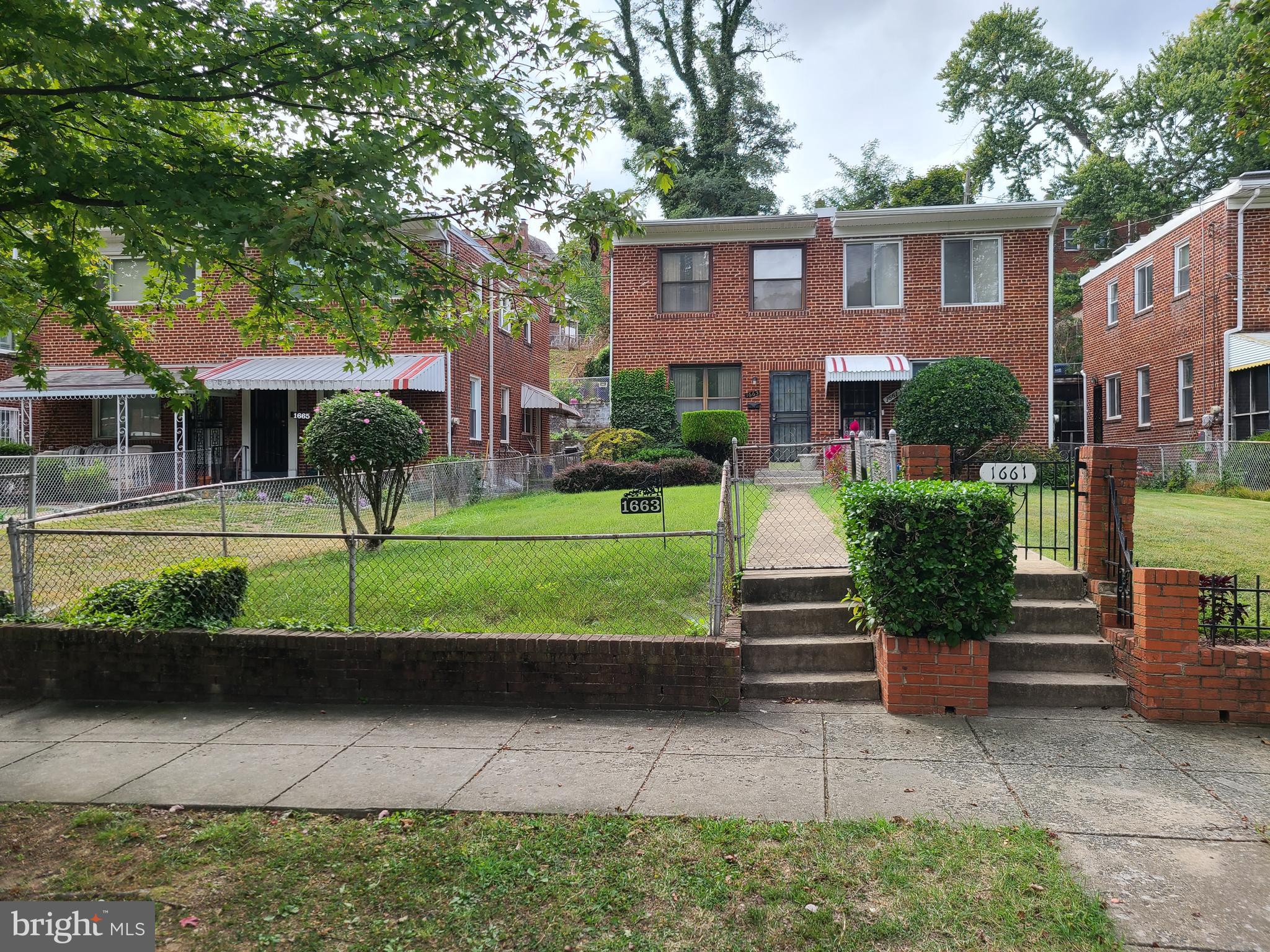 a front view of a house with a yard and potted plants