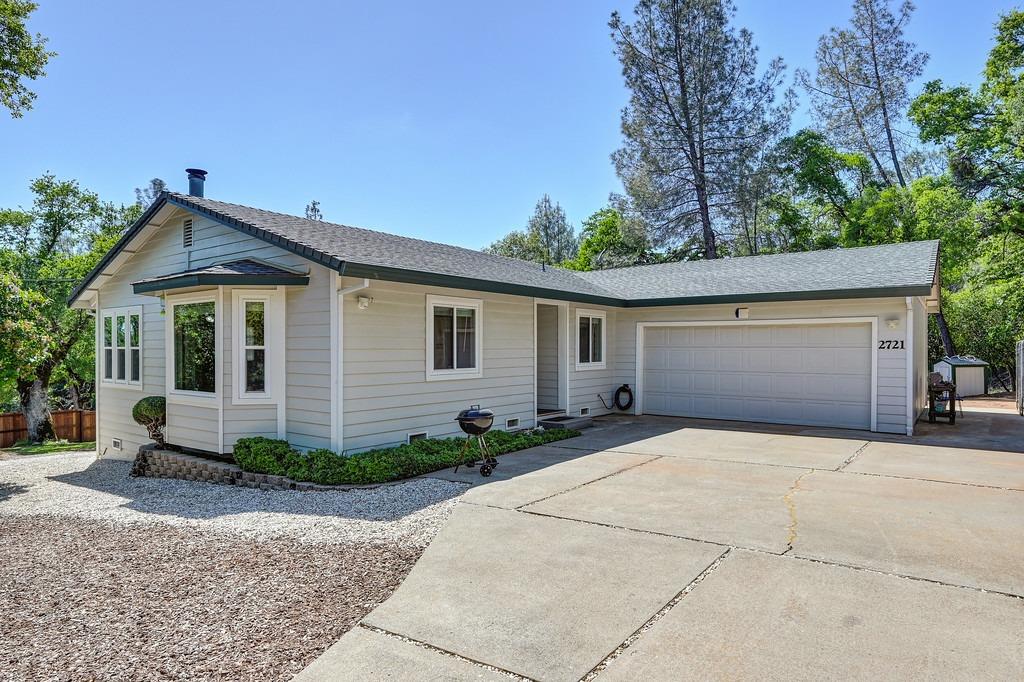 a front view of house with yard and trees in the background