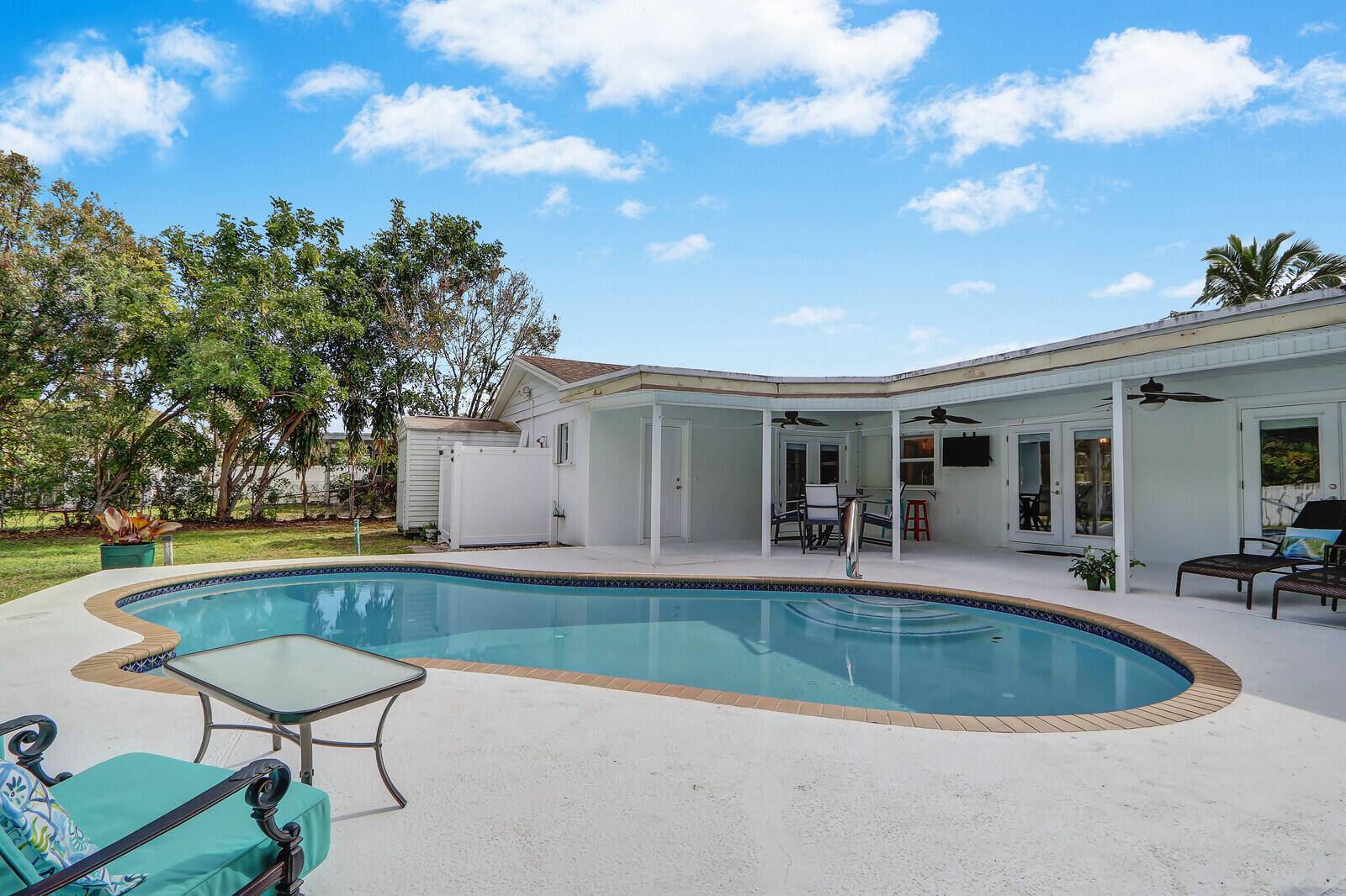 a view of a house with swimming pool and sitting area