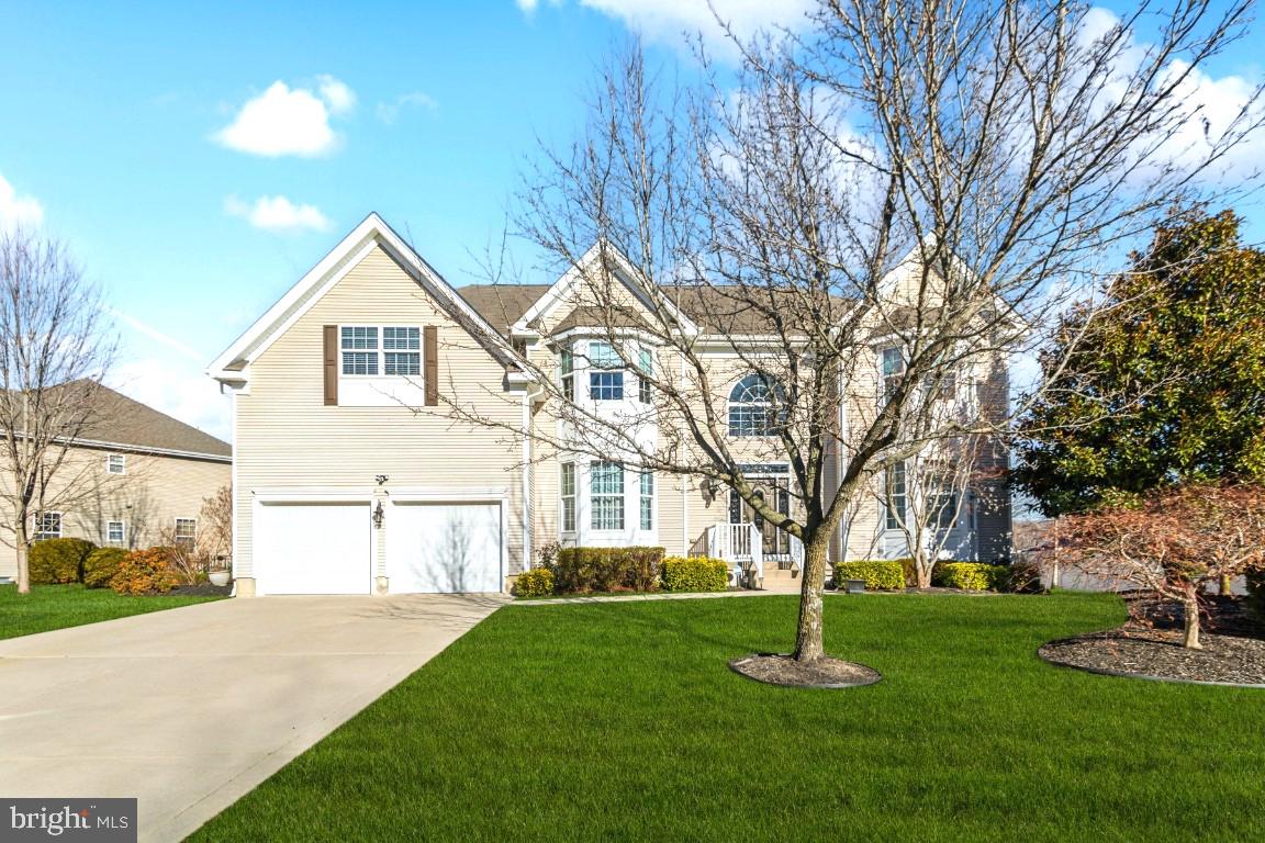 a front view of a house with a garden and trees