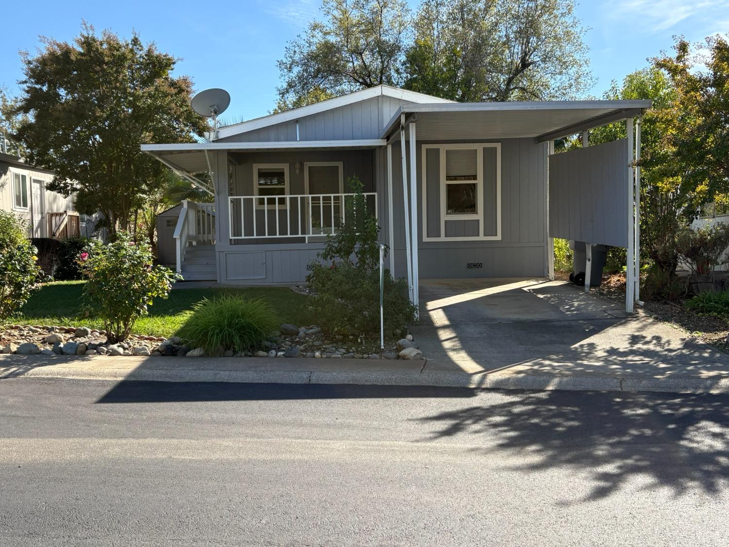 a front view of a house with a yard and trees