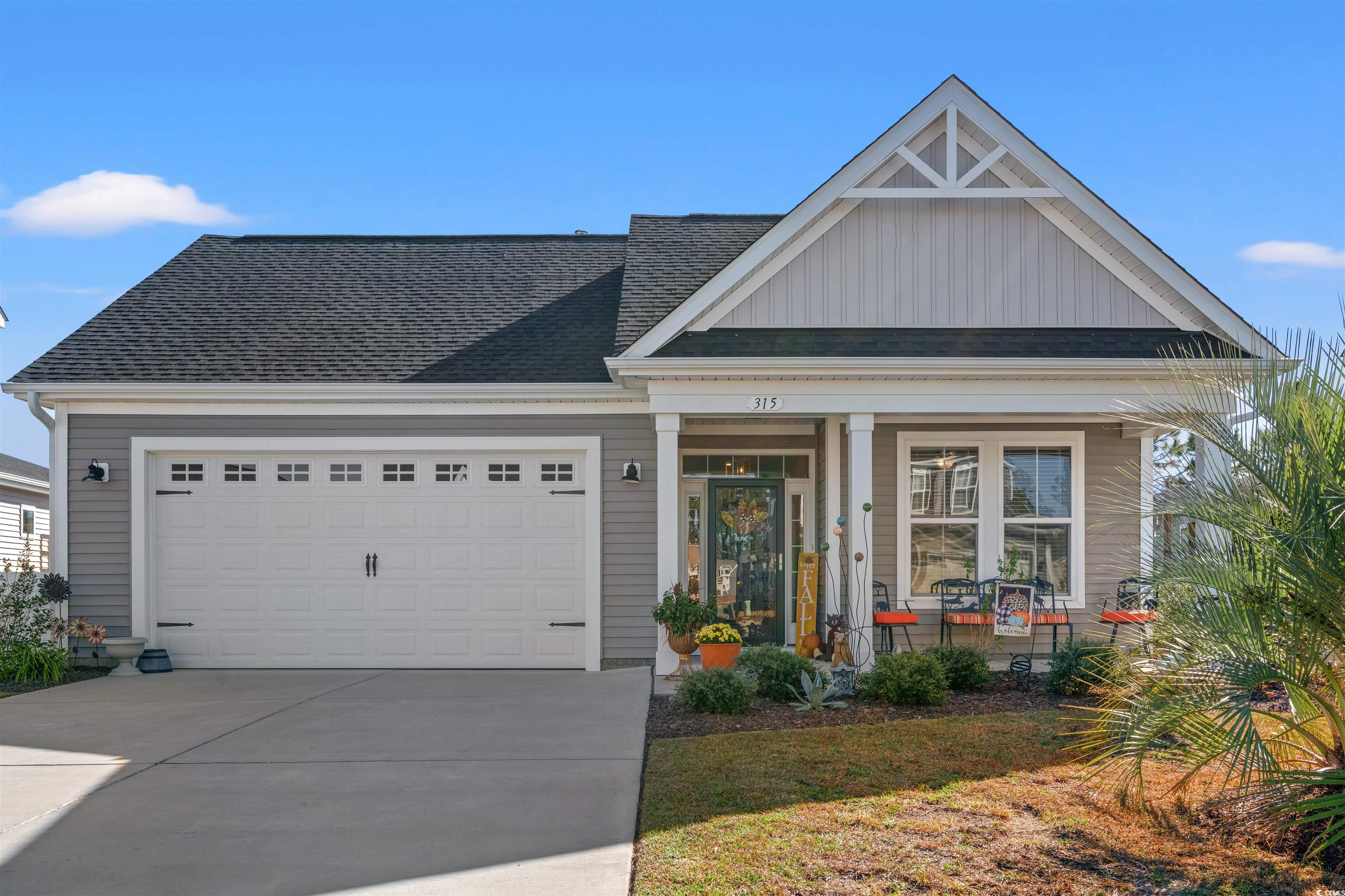 View of front of home featuring a porch and a gara