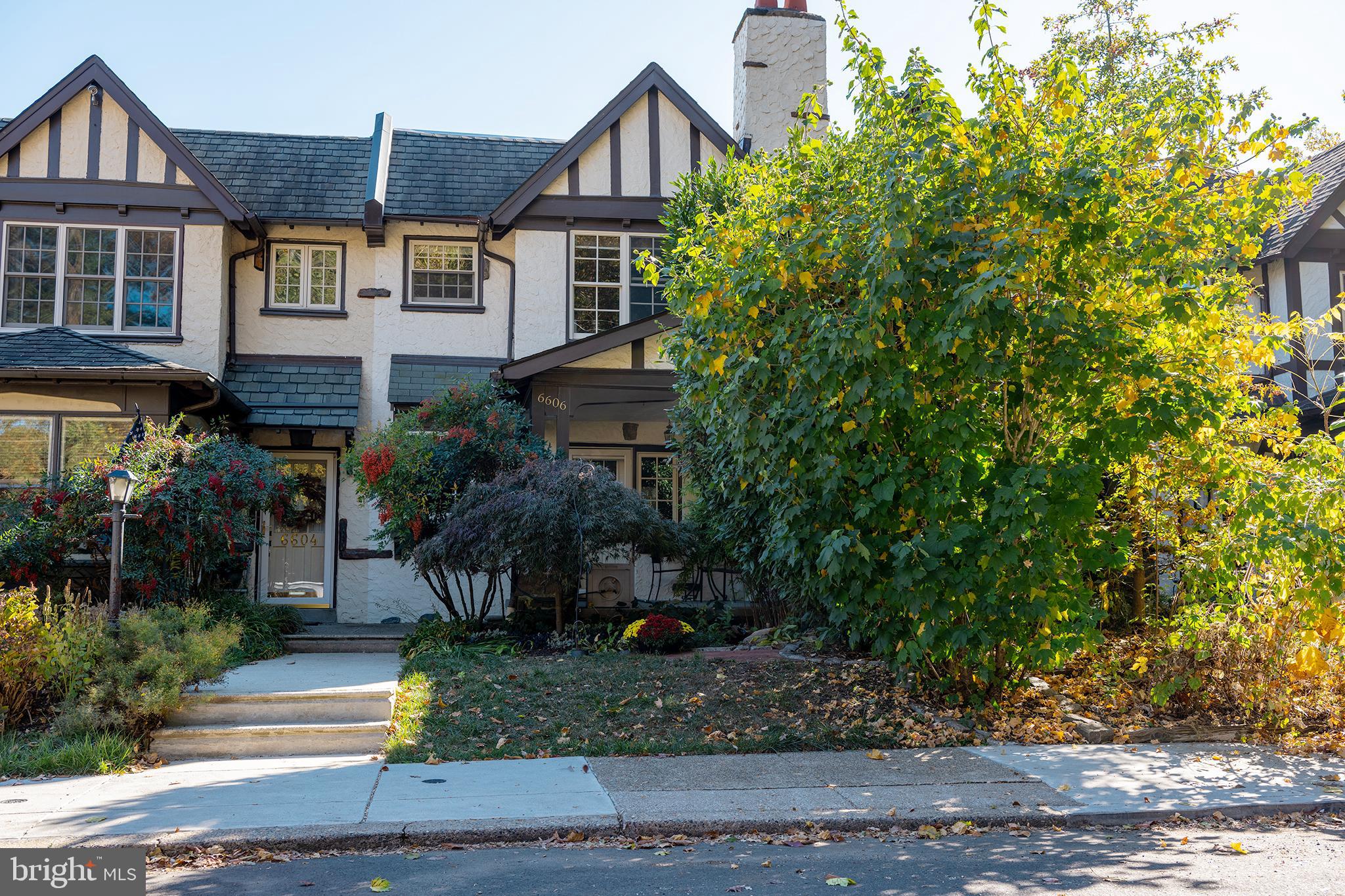 a view of a brick house with a yard and large trees