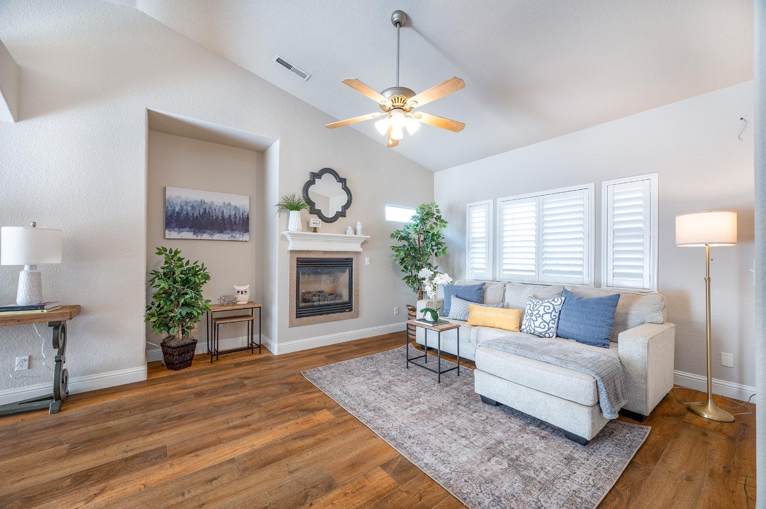 a living room with furniture a fireplace and a large window