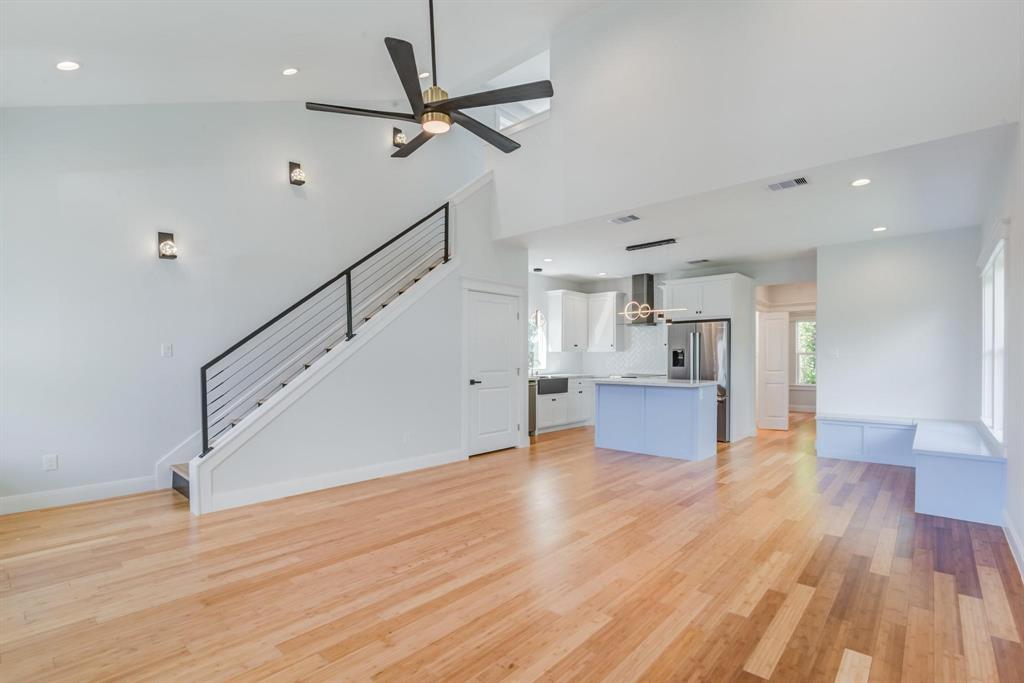 a view of a kitchen with wooden floor and a ceiling fan