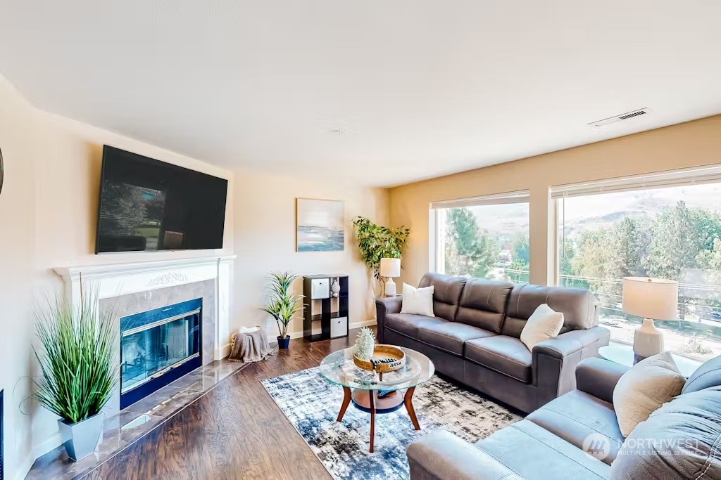 a living room with furniture a fireplace and a flat screen tv