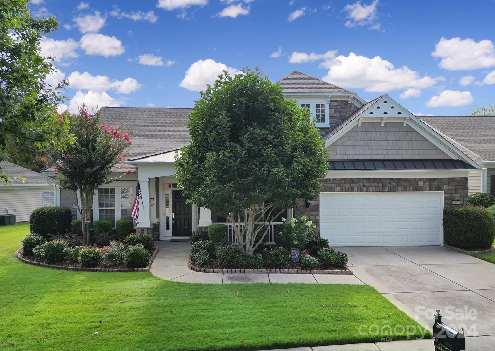 a front view of a house with a yard and potted plants