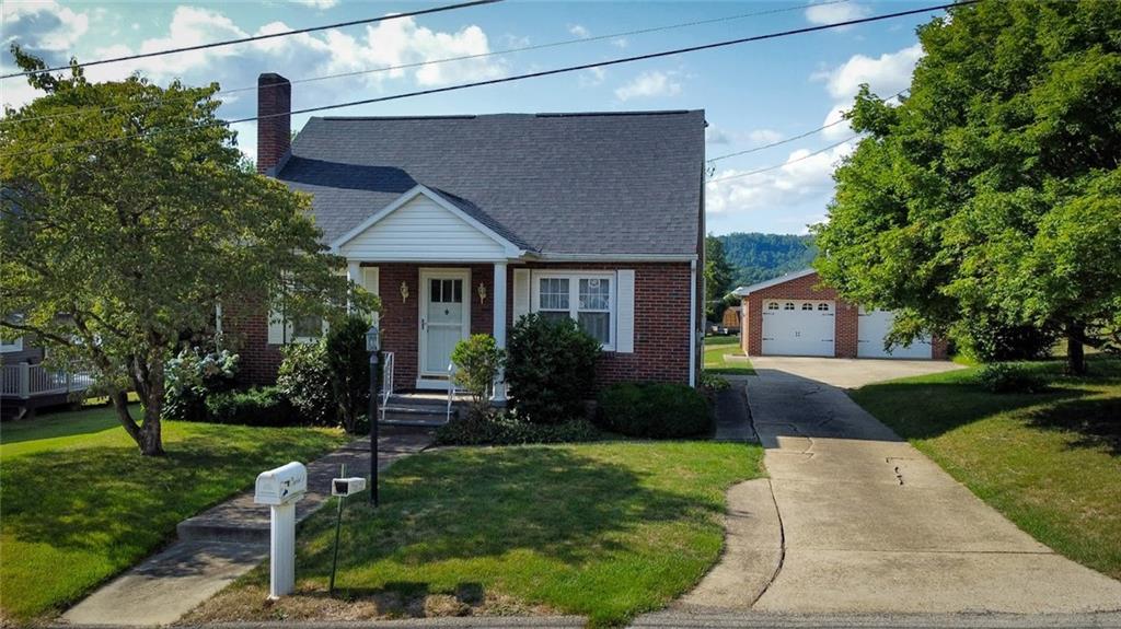 a front view of a house with a yard and trees