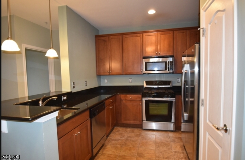 a kitchen with granite countertop stainless steel appliances a stove sink and microwave