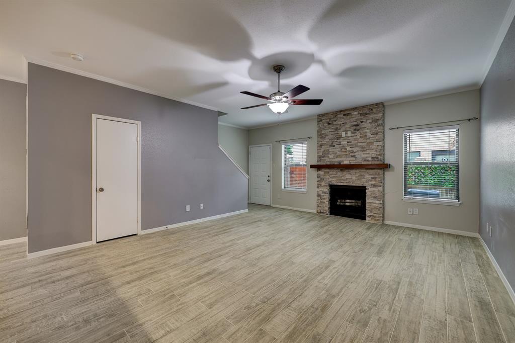 a view of an empty room with a fireplace and a window