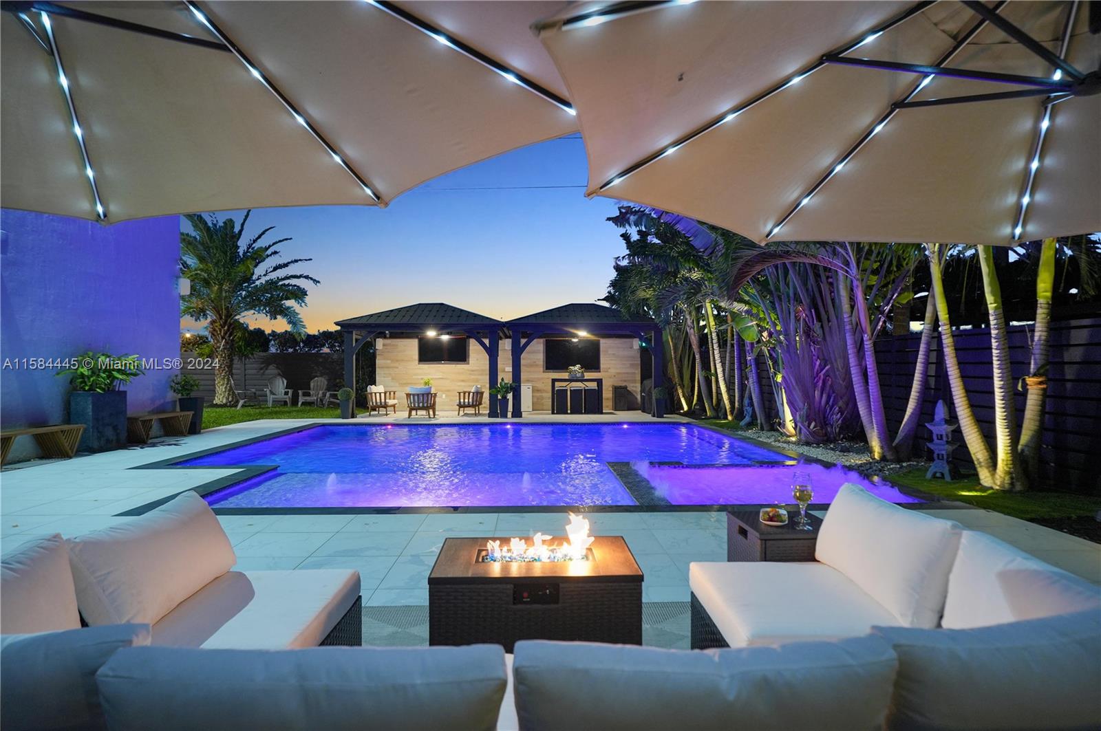 a view of swimming pool with red chairs under an umbrella