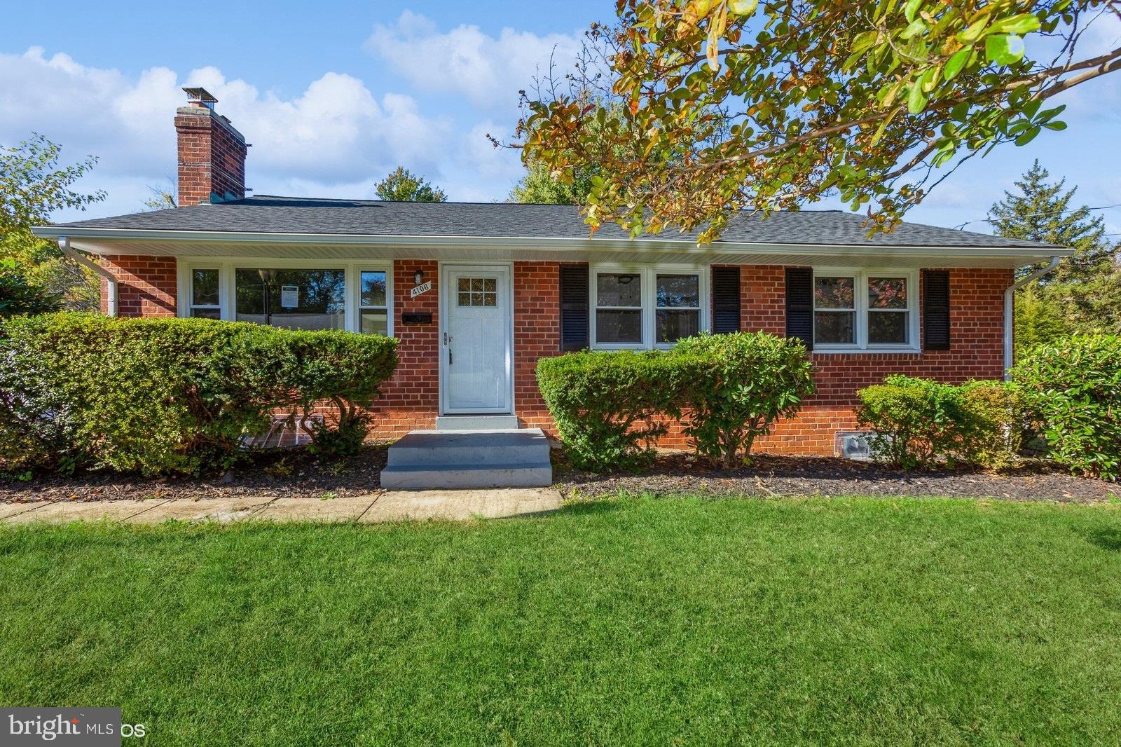 a front view of a house with a yard and potted plants