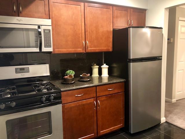 a kitchen with stainless steel appliances granite countertop a refrigerator stove and sink