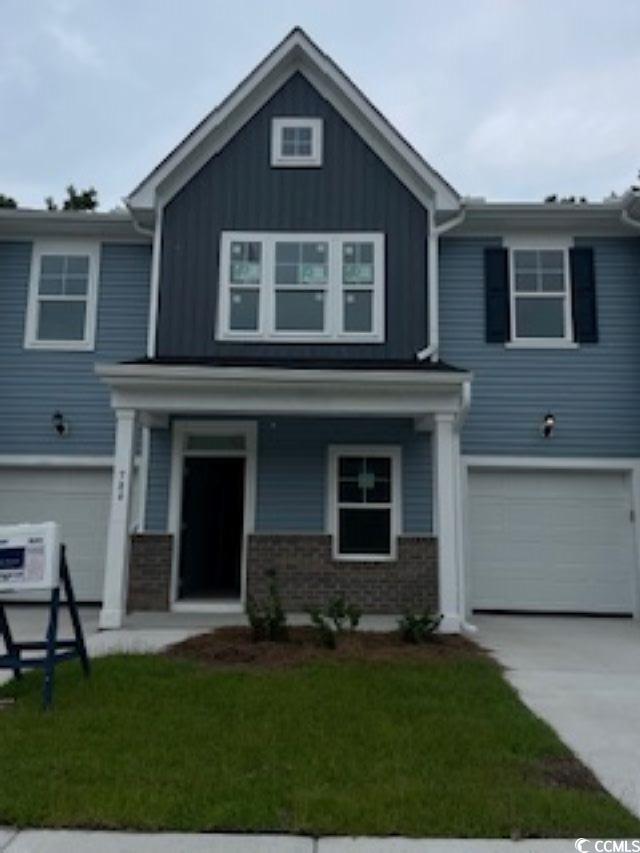 View of front of home with a front lawn, a garage,