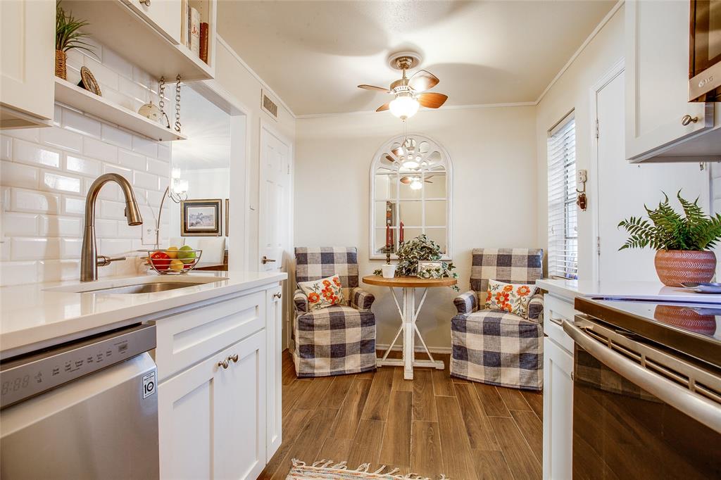 a very nice looking dining room with a large kitchen island lots of white furniture and chandelier