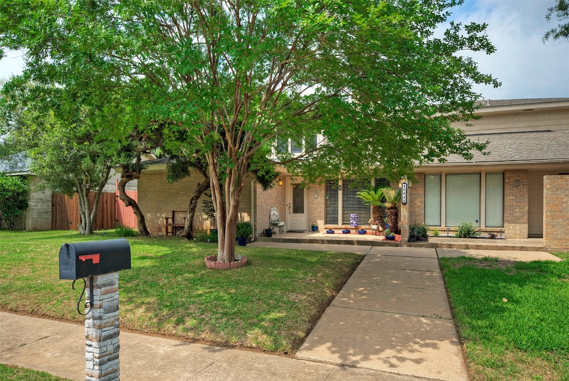 a front view of a house with a yard and trees