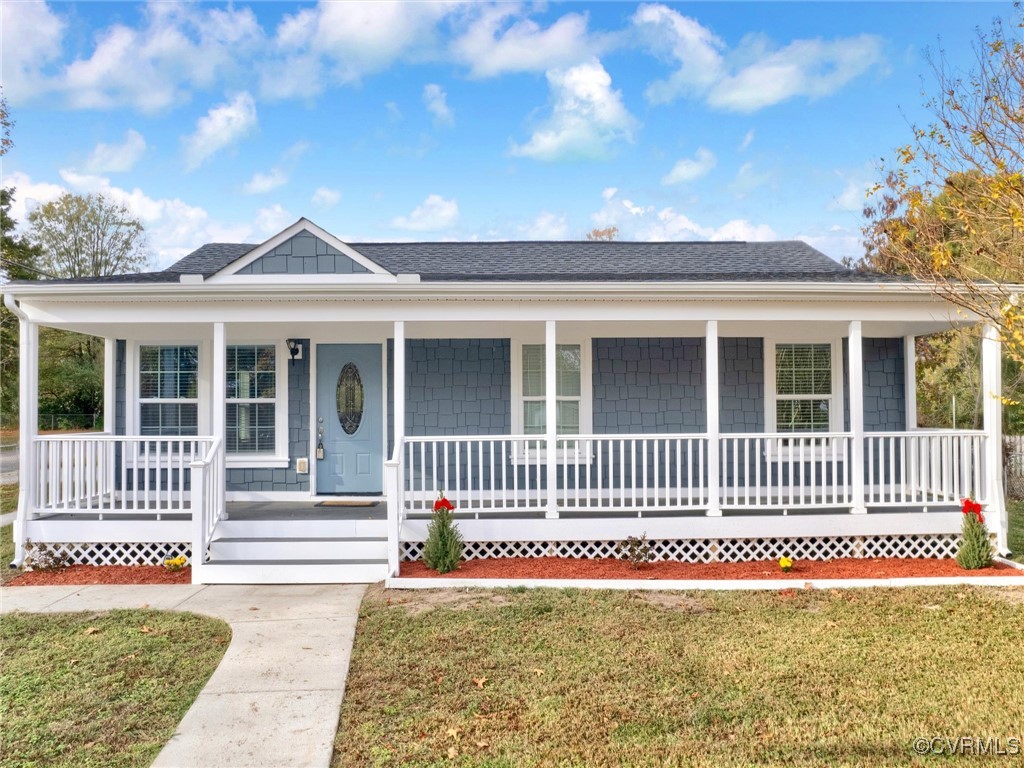 Ranch-style home featuring a front lawn and a porc