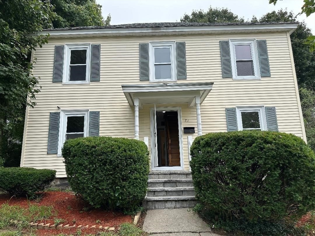 a view of a house with a small yard and plants