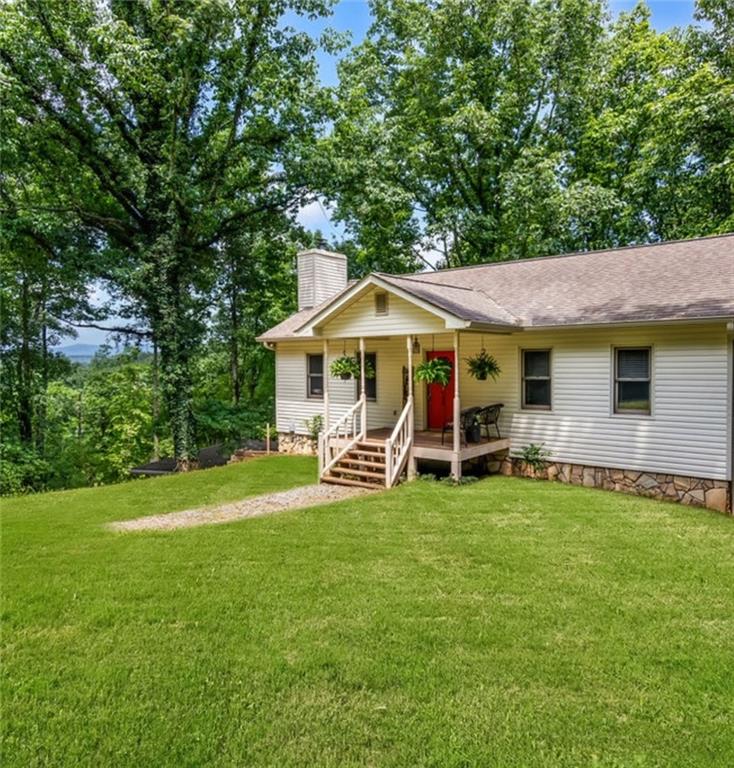 a view of a house with a yard and sitting area