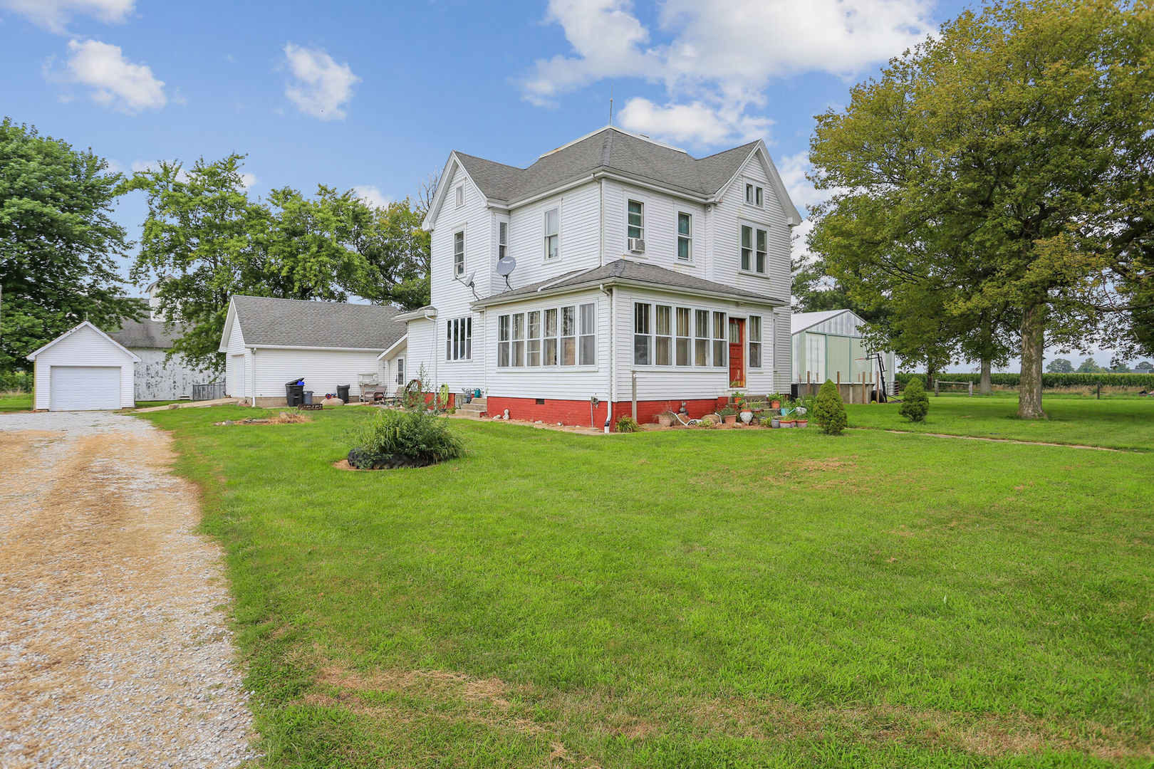 a front view of a house with garden and trees