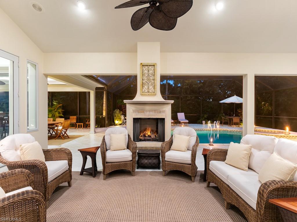 a living room with furniture a fireplace and a chandelier