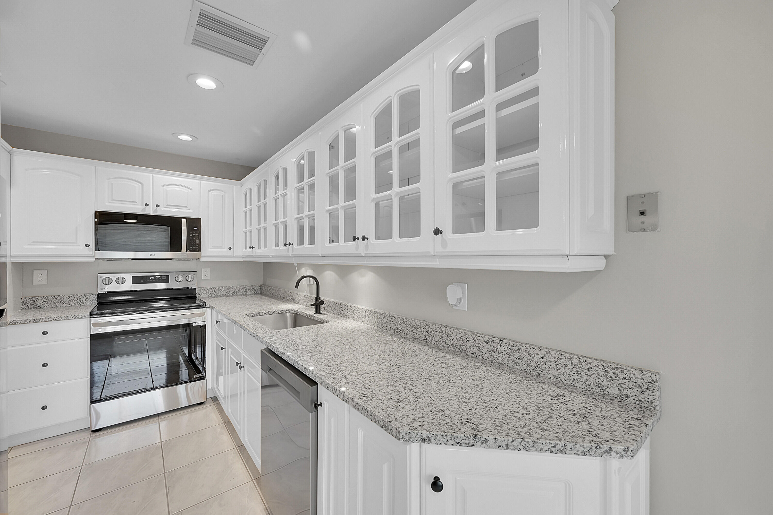 a kitchen with stainless steel appliances granite countertop a sink stove and cabinets