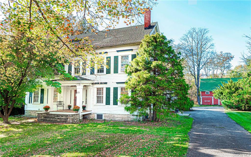 a front view of a house with a garden and trees