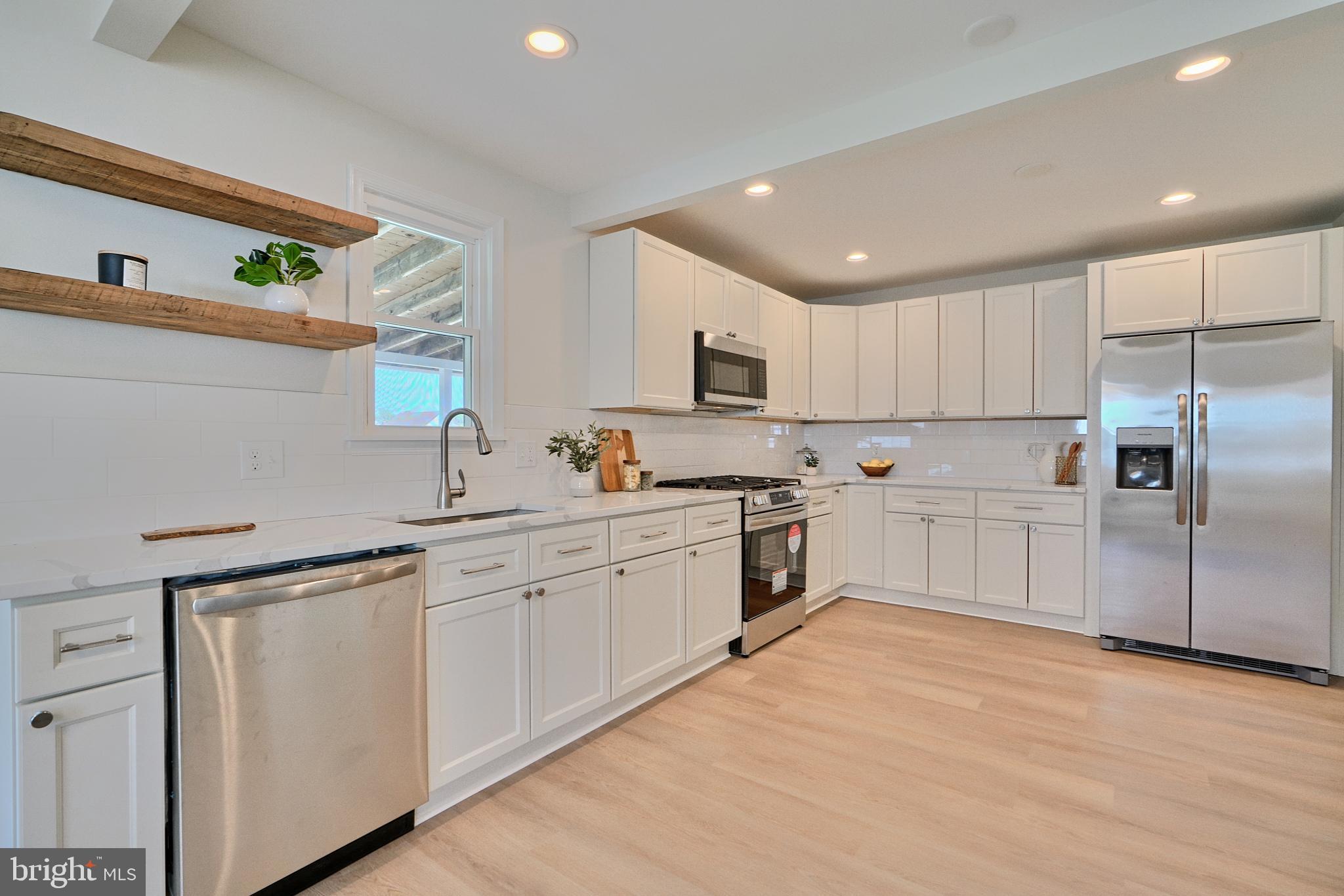 a kitchen with white cabinets and white appliances