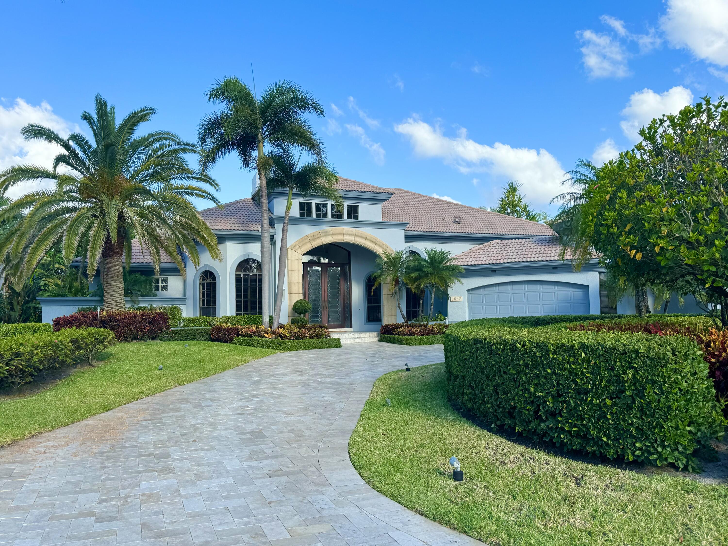 a view of a house with a yard and potted plants