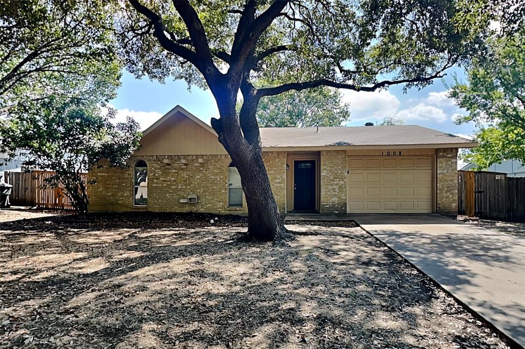 a view of a house with a tree in front of it