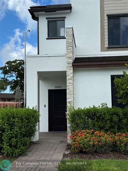 a front view of a house with a garden