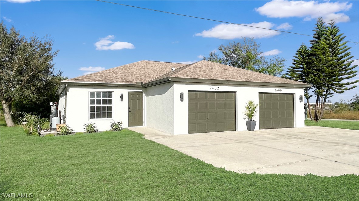 a front view of a house with a garden and yard