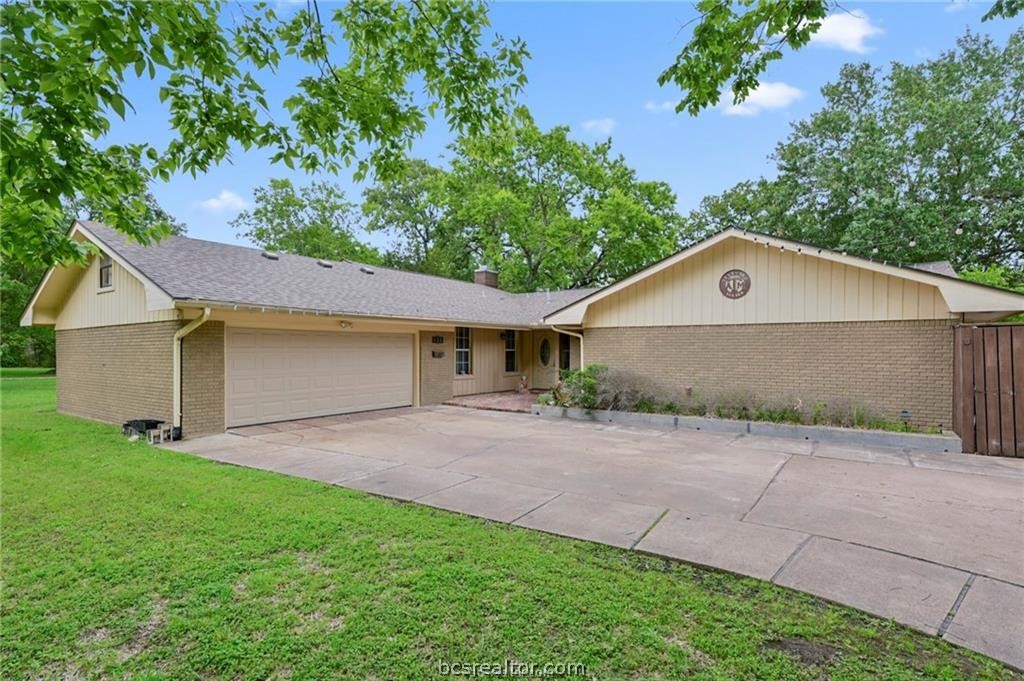 a front view of house with yard and trees all around