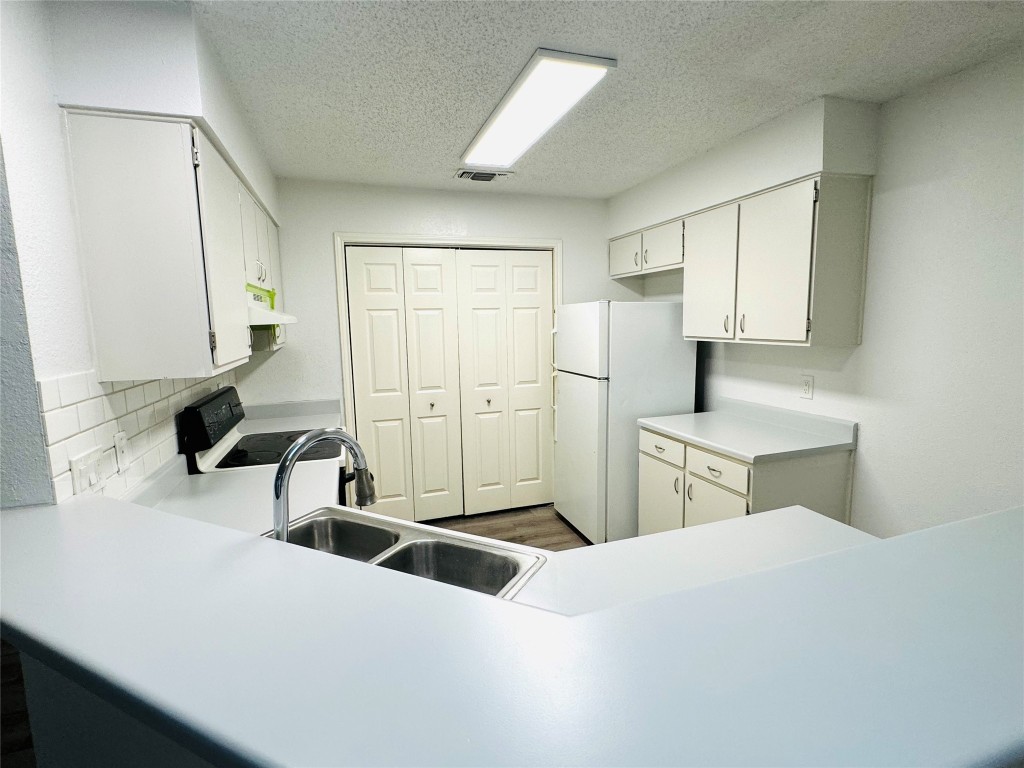 a kitchen with stainless steel appliances a sink and a refrigerator