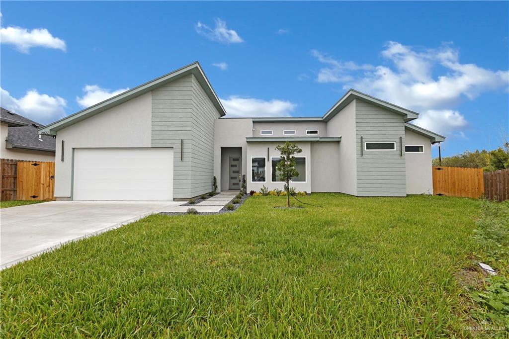 a front view of house with yard and garage