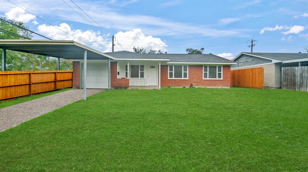 a front view of a house with a yard and potted plants