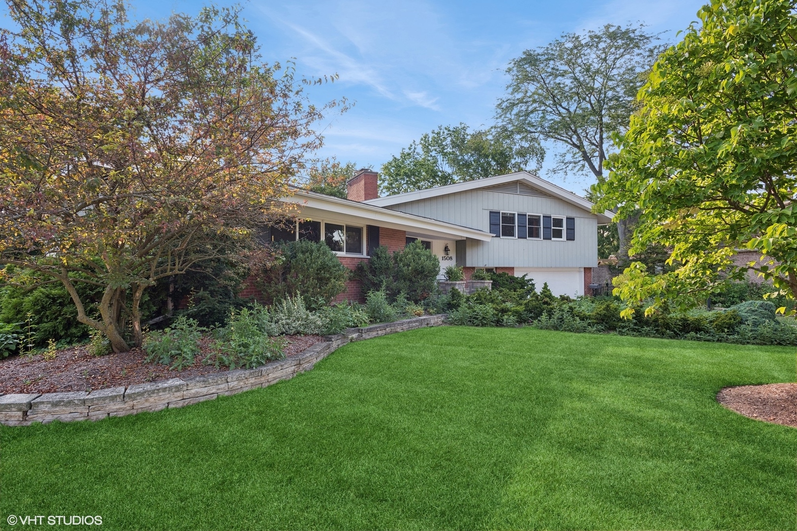 a front view of a house with a yard and trees