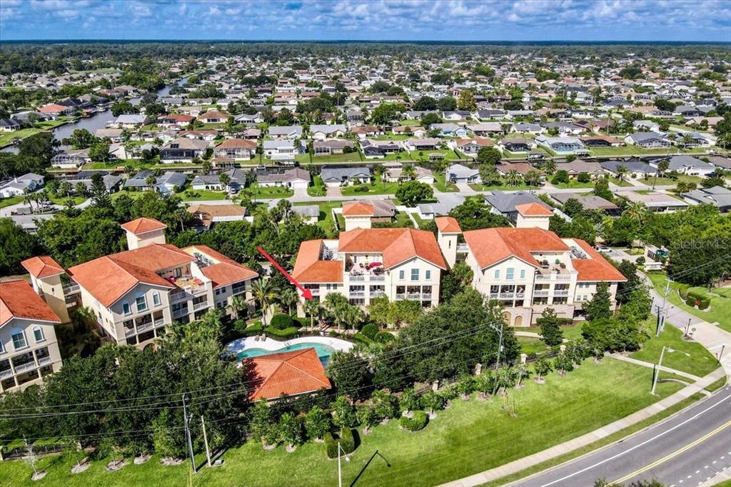 an aerial view of residential houses with outdoor space and trees