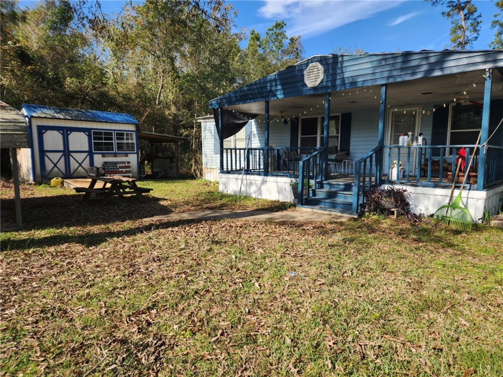 View of yard with covered porch and a shed