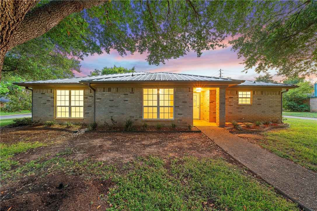 a view of a house with backyard and a tree