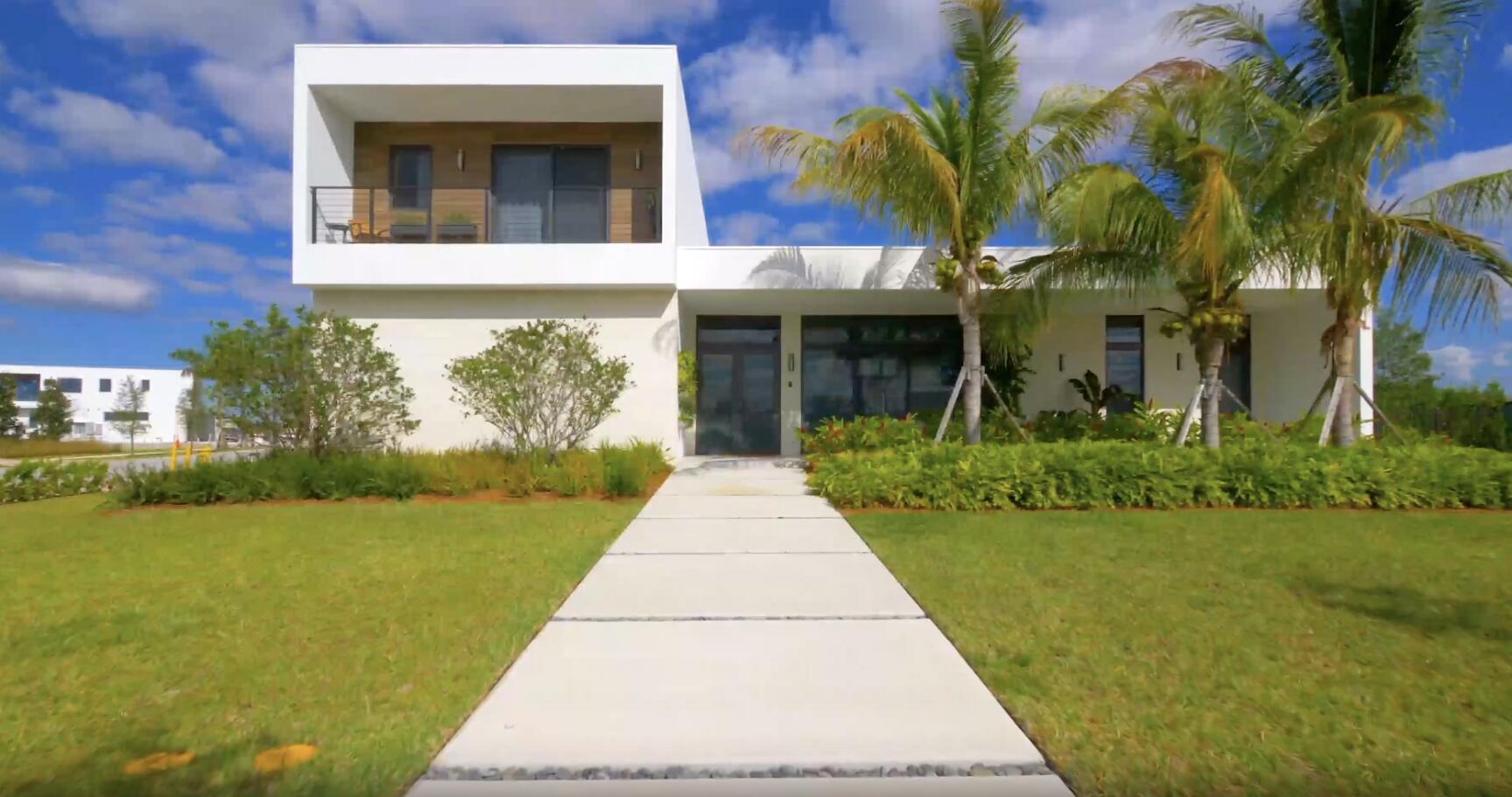 a front view of a house with a garden and yard