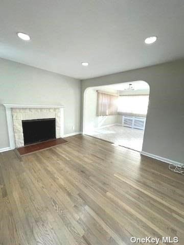 an empty room with wooden floor and fireplace