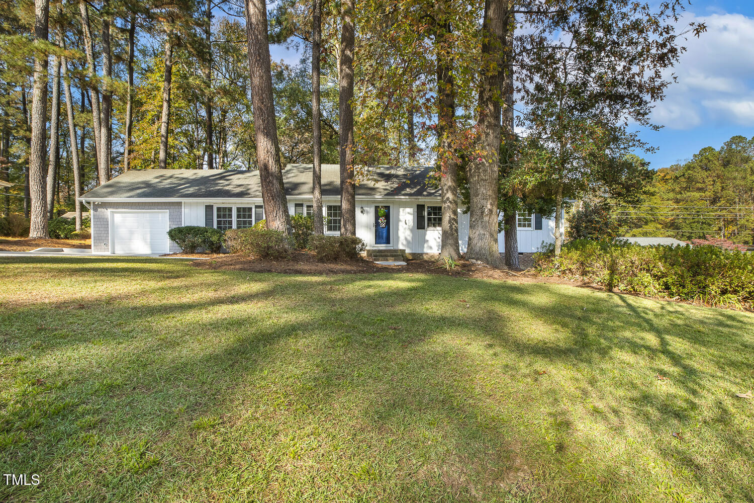 a view of a house with a big yard and large trees