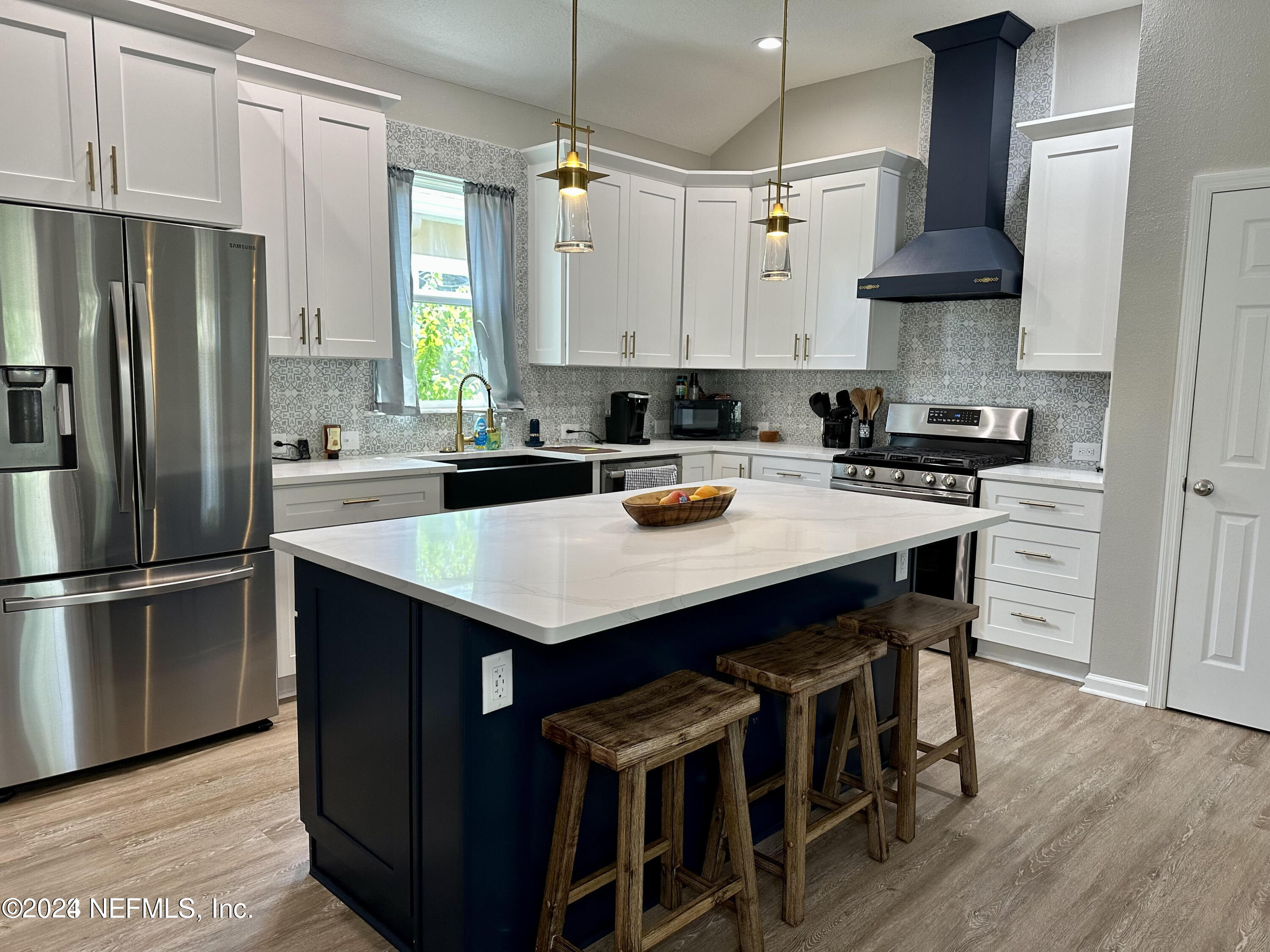 a kitchen with stainless steel appliances a table chairs stove and refrigerator