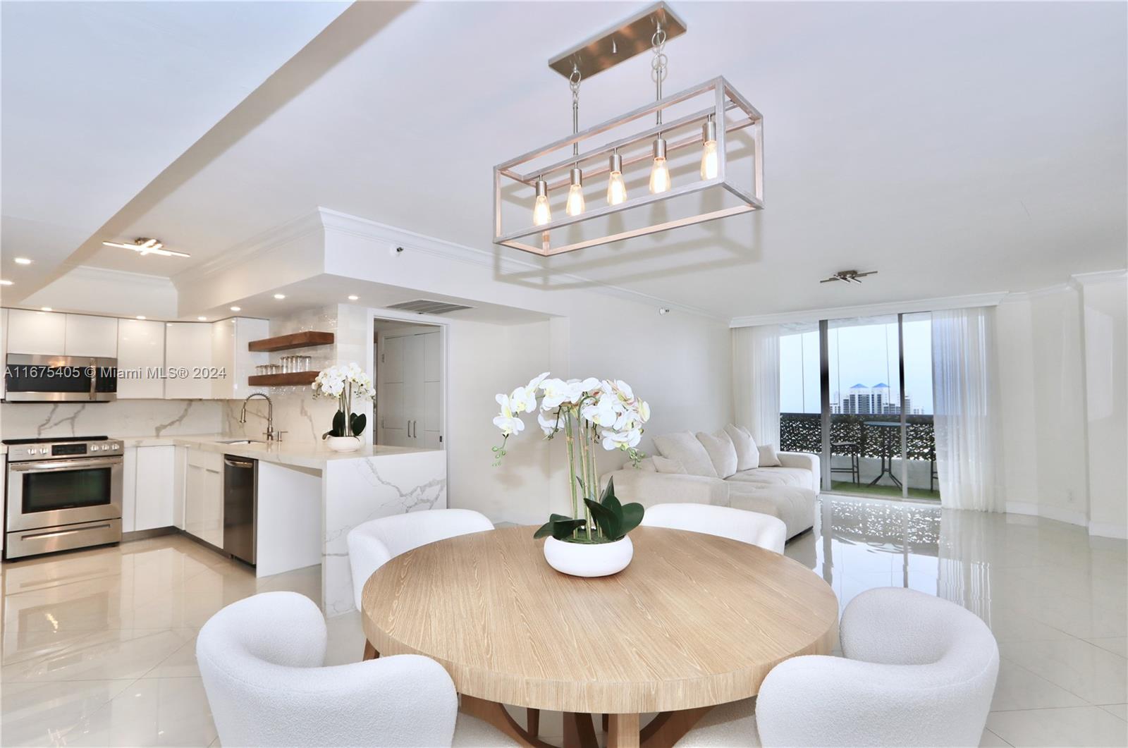 a dining room with kitchen island furniture a chandelier and kitchen view