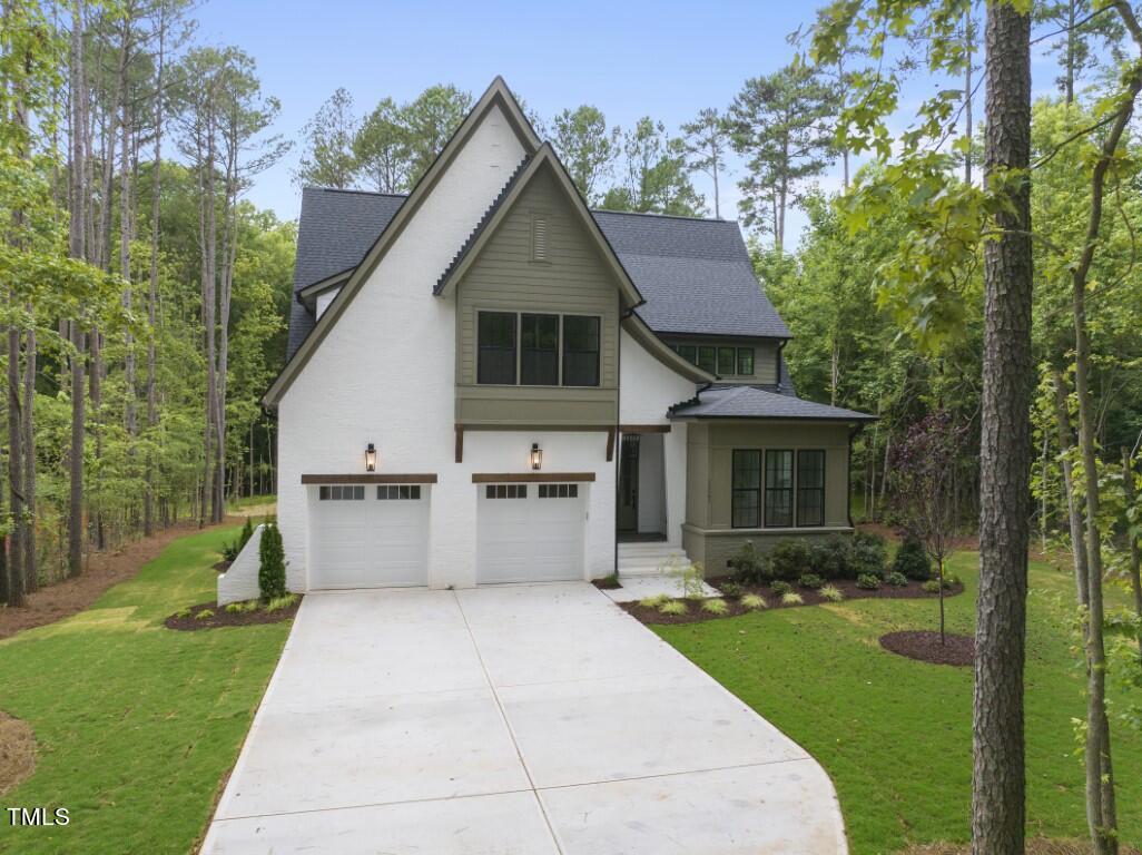 a front view of a house with a yard and trees