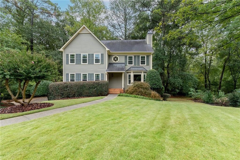 a front view of a house with a yard and trees