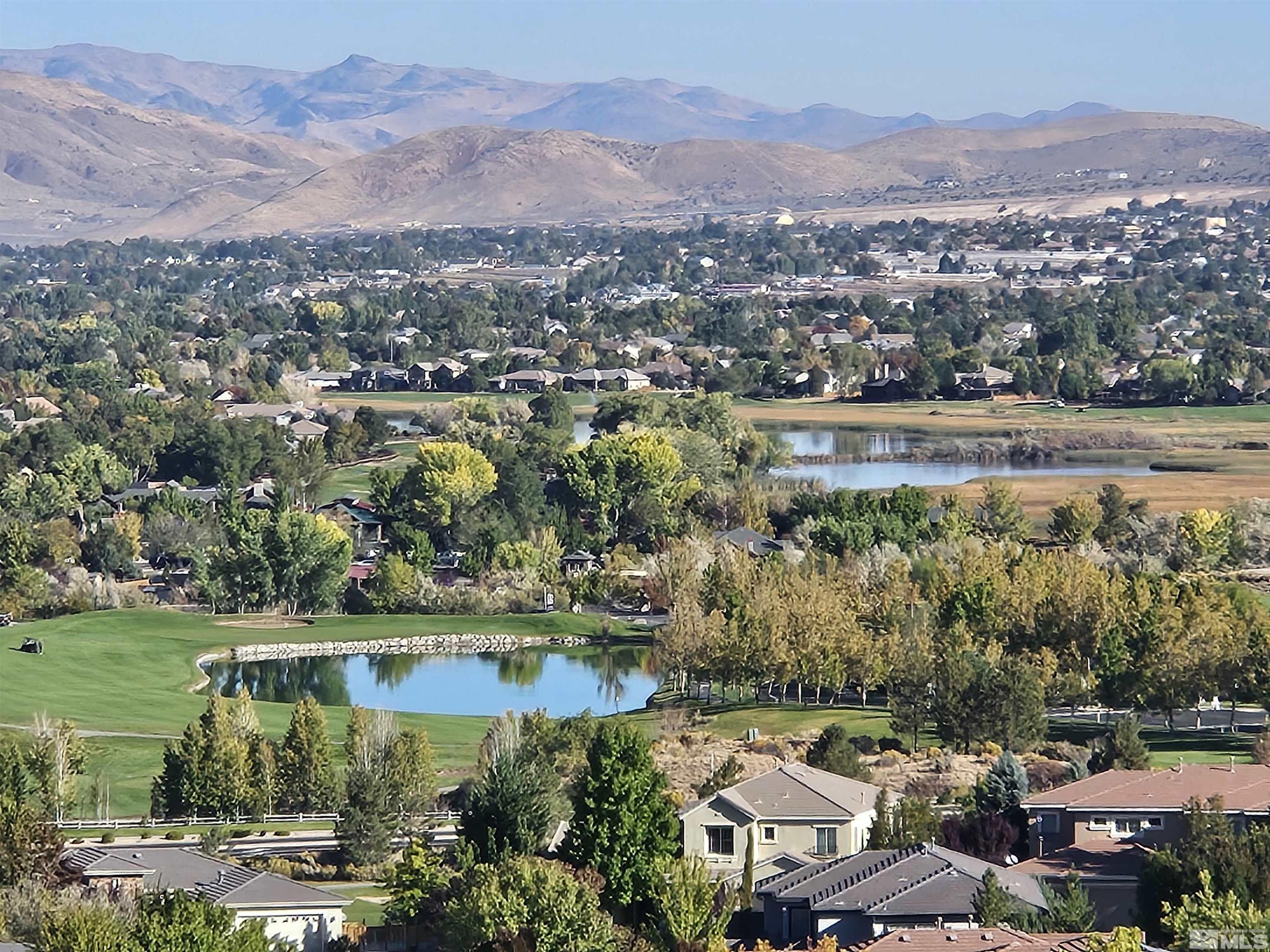 an aerial view of residential houses with outdoor space and lake view